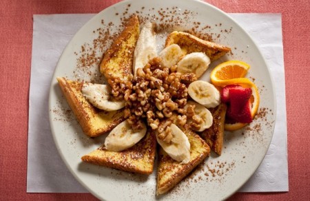a picture of french toast with banana on top and cinamon